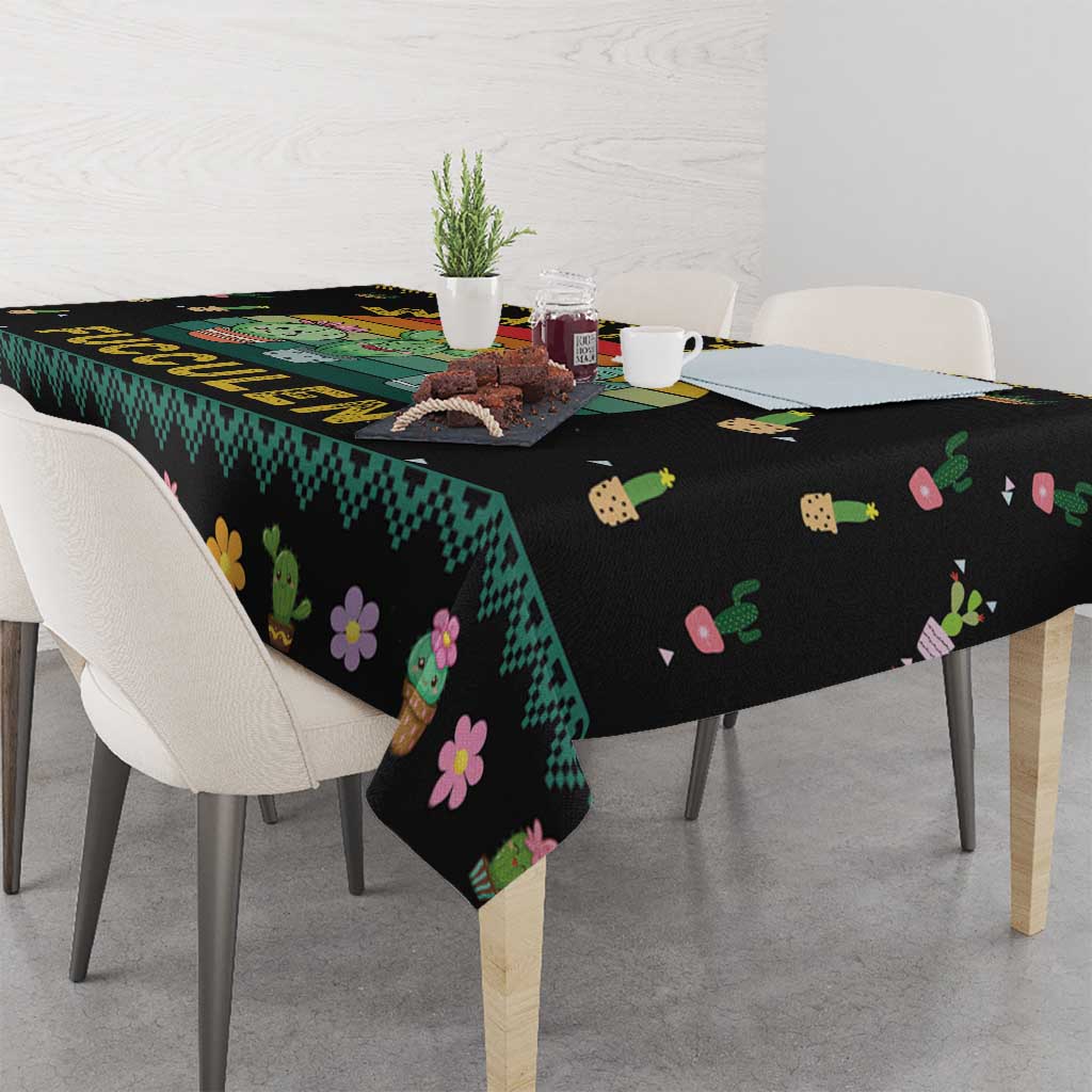 Black tablecloth draped over table corner with cactus, succulent, and flower pattern