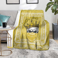 Yellow paisley throw blanket with crowned face motif, spread on a rug