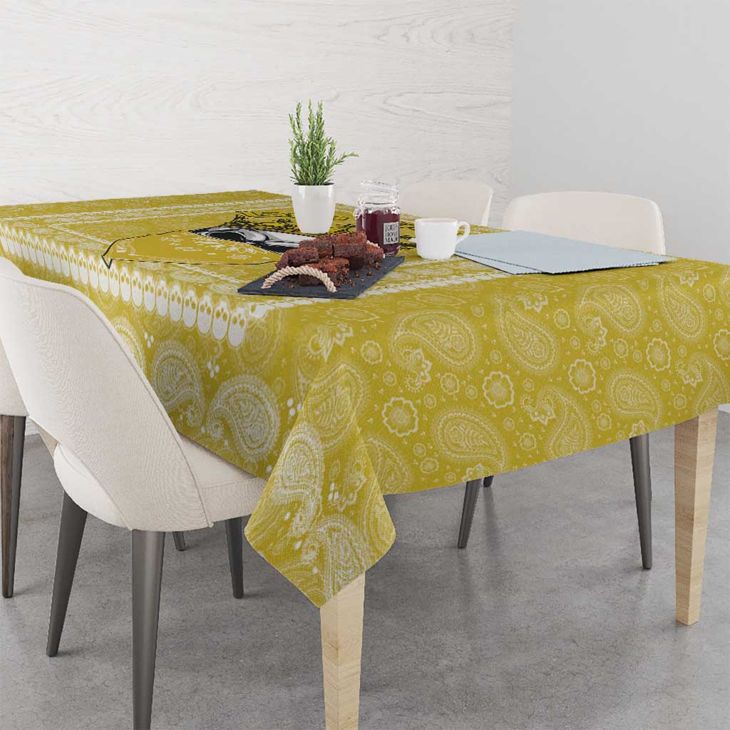 Yellow paisley-pattern tablecloth with scalloped lace-style border along the edge.