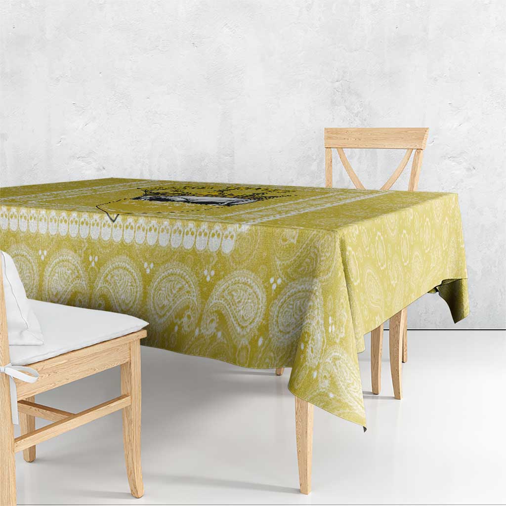 Yellow paisley-pattern tablecloth corner drape on a rectangular table.