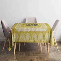 Yellow paisley-pattern tablecloth on a square table with four upholstered chairs.