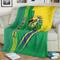 Green Brazil flag toucan blanket on cream sofa, yellow/blue stripes and toucan graphic