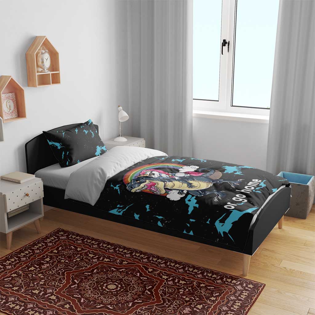 Black bedding set on bed with blue splatter dinosaur and unicorn graphic, “or go home”