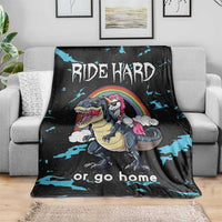 Black dinosaur-unicorn blanket draped over a sofa, showing rainbow and "RIDE HARD"