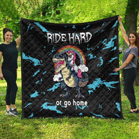 Black quilt laid out outdoors, Ride Hard dinosaur-unicorn design with rainbow and blue accents.