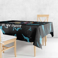 Black dinosaur unicorn tablecloth with blue splash pattern, corner draped over table.