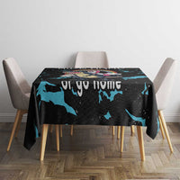 Black dinosaur unicorn tablecloth with blue splash pattern covering square dining table.