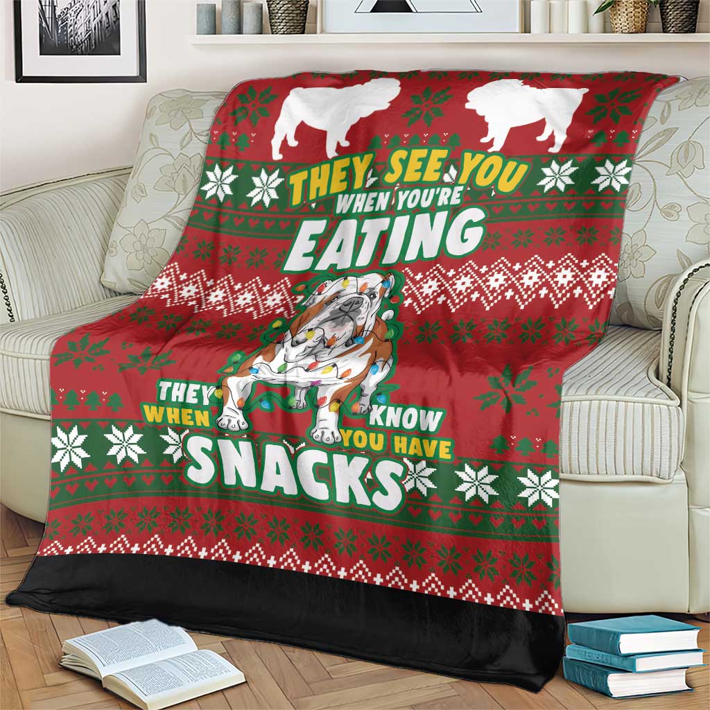 Red Christmas dog blanket on cream sofa, bulldog graphic and bold “SNACKS” text