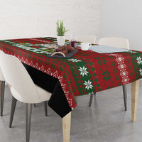 Red Christmas tablecloth with green snowflake pattern draped over dining table