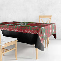 Red Christmas tablecloth with green snowflake pattern draped along table edge