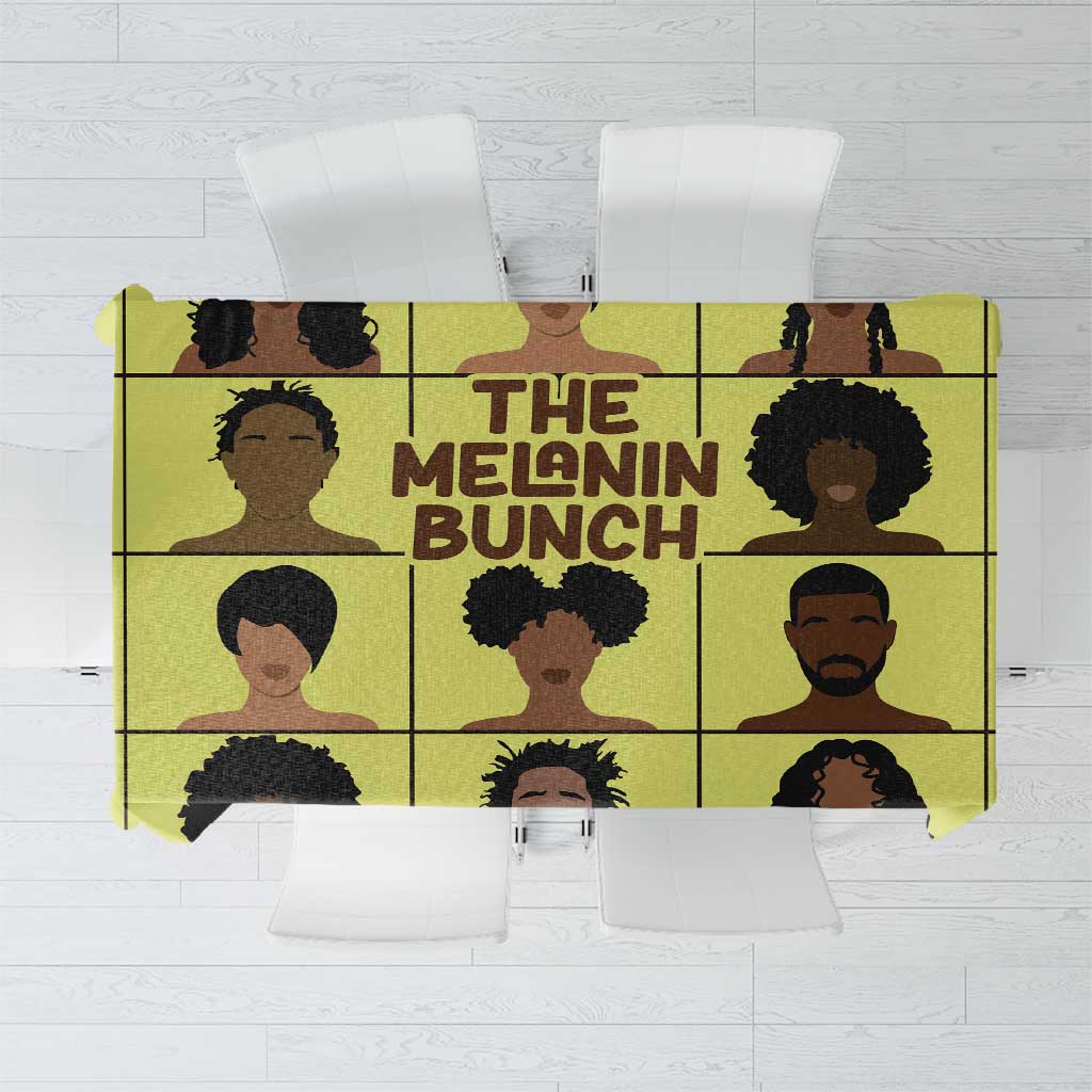 Yellow African-themed tablecloth with grid portraits of people in black and brown.