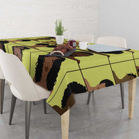 Yellow tablecloth featuring repeating grid portraits of people in black and brown.