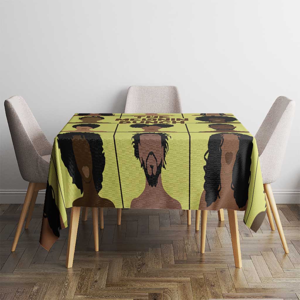Yellow tablecloth with repeating portrait blocks in black and brown on dining table.