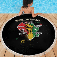 Black round beach blanket with white fringe and colorful African graphic on deck