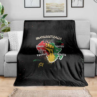 Black throw blanket with centered roots and strength quote graphic on sofa