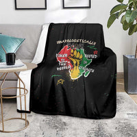 Black throw blanket with colorful roots and strength message graphic on floor