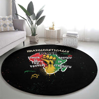 Black round carpet with colorful African roots lettering and lion emblem