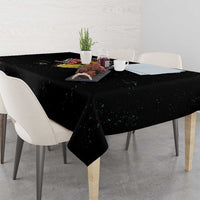 Black tablecloth with colorful splash of text and imagery, draped over a dining table