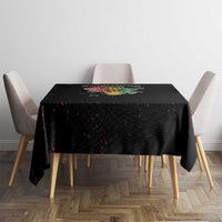 Black tablecloth with colorful text-and-roots graphic on top, set for a dining table