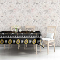Black tablecloth with golden sun spiral motifs across table surface and hanging edges