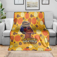 Yellow throw blanket on sofa with African face graphic and repeating circular motifs