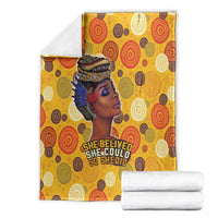 Yellow blanket with African woman portrait; folded white towels, 'She believed...' text