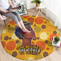 Yellow round area rug featuring tribal profile artwork and “She Believed” lettering