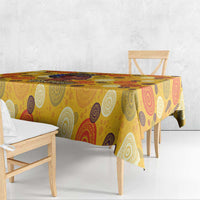 Yellow circular-pattern tablecloth over wooden dining table and bench seating