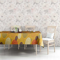 Yellow tablecloth with circular motifs on long table behind white chairs
