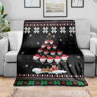 Black Christmas snow blanket draped on sofa, showing Santa-style characters and pine trees