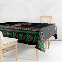 Black Christmas tablecloth with green starburst and red geometric trim, table edge view
