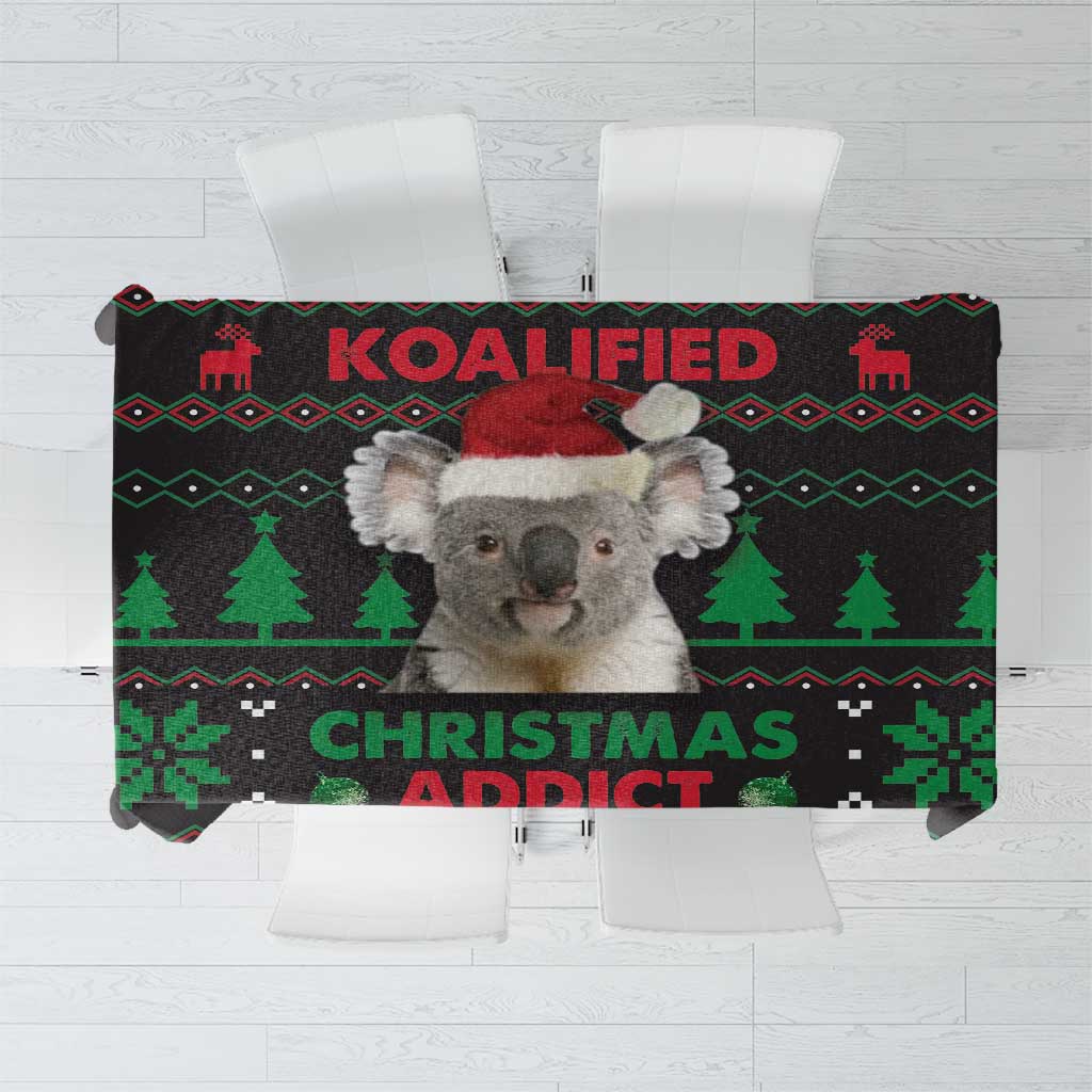 Black Christmas tablecloth with koala graphic, Koalified text, and green tree pattern