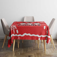 Red Christmas tablecloth with gnomes and white dots, stars, and stripe border on table.