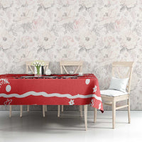 Red holiday tablecloth with white wave stripe and snowflake/star motifs on dining table.