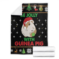 Black Christmas blanket with guinea pig print, shown folded with white roll blankets