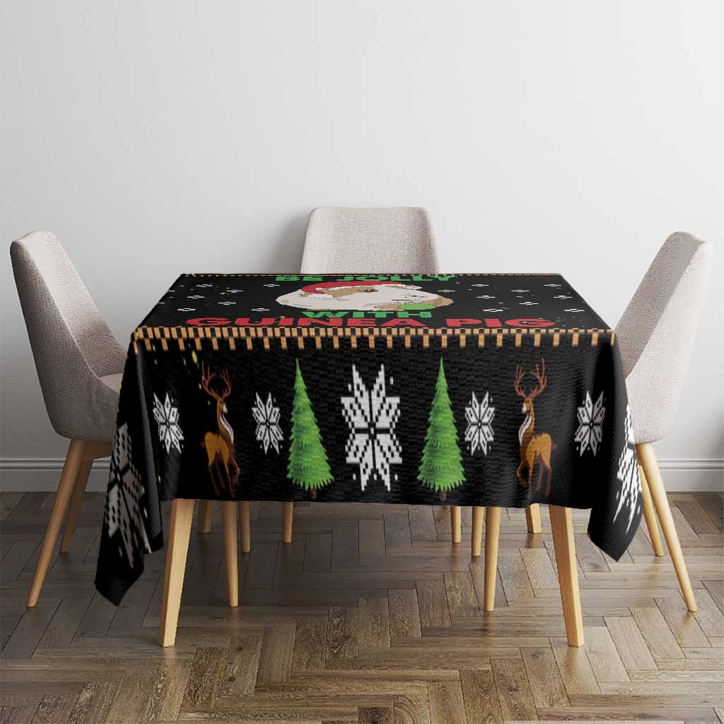 Black Christmas tablecloth with green trees, snowflakes, and reindeer icons on table