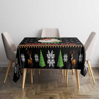 Black Christmas tablecloth with green trees, snowflakes, and reindeer icons on table