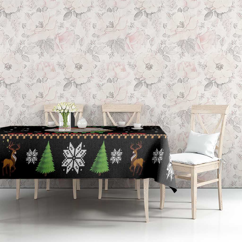 Black Christmas tablecloth with green tree and snowflake patterns on dining table