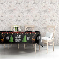 Black Christmas tablecloth with green tree and snowflake patterns on dining table
