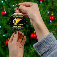 Black ceramic Christmas ornament held in hand, gold loop and “I SAID I CAST FIREBALL” text