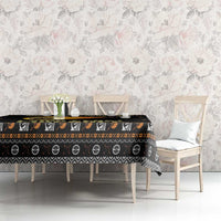 Black tablecloth on dining table with repeating icons, orange fireball band, and star dots