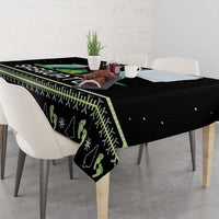 Black tablecloth with pine tree and snowflake pattern over table corners