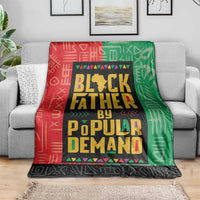 Multicolor African blanket draped over a sofa; red, green, and black geometric text