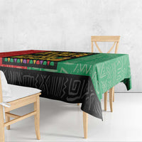 African tablecloth with green top section and black lower panel; draped on table