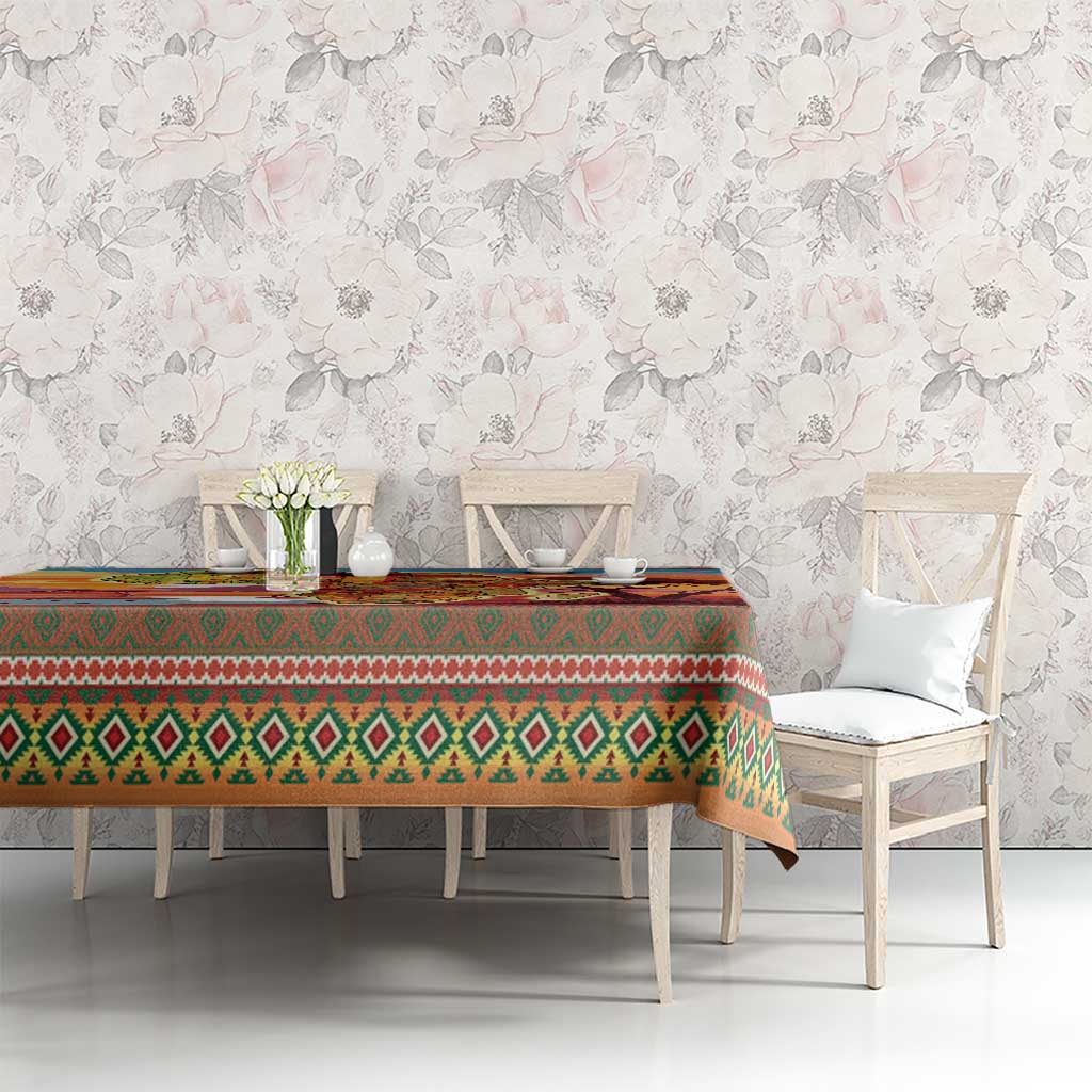 Christmas tablecloth covering dining table with green diamond band and festive icons