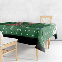 Green tablecloth draped over dining table edge with printed heart and tree icons