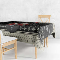 Black Christmas tablecloth with snowflake motifs and patterned border, laid on bench