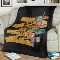 Black blanket draped on sofa with colorful quote graphic and small vertical patch labels