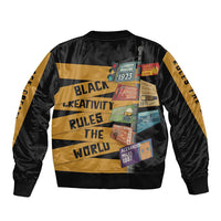 Black bomber jacket with gold stripes, ribbed cuffs, and colorful patch collage panel