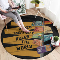 Round black and gold area rug with 'Black Creativity Rules The World' text and patchwork